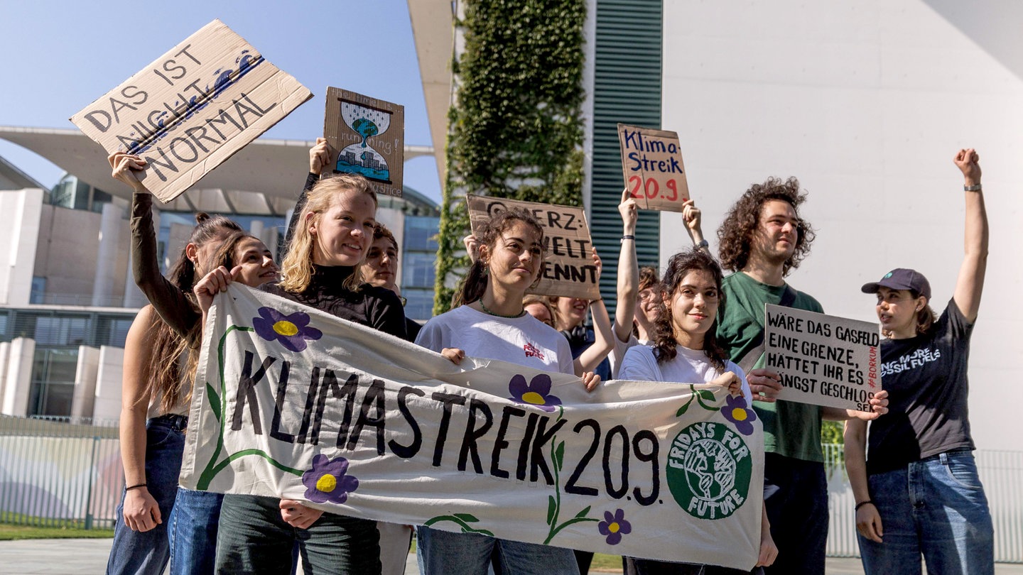 Mitglieder von Fridays for Future Deutschland halten vor dem Bundeskanzleramt bei einer Pressekonferenz zum geplanten globalen Klimastreik am 20. September 2024 ein Transparent mit der Aufschrift 