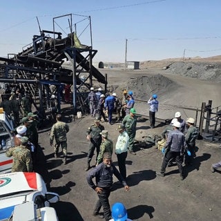 HANDOUT - Auf diesem von der iranischen Gesellschaft des Roten Halbmonds veröffentlichten Foto sind Bergleute und Polizisten am Standort einer Kohlemine etwa 540 Kilometer südöstlich der iranischen Hauptstadt Teheran zu sehen. Bei einer Gasexplosion in einem Kohlebergwerk im Nordostiran sind bislang mindestens 30 Arbeiter ums Leben gekommen. Die Explosion, verursacht durch ein Gasleck, ereignete sich im Kohlebergwerk in der Stadt Tabas.