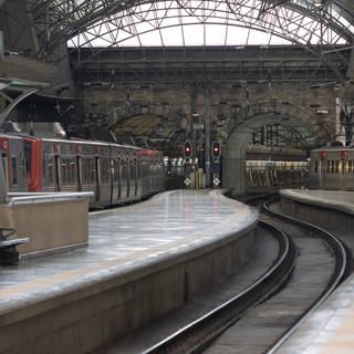 Leerer Bahnhof mit einfahrenden Zügen in Portugal.