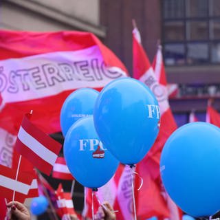 Luftballons und Österreich-Fahnen: In Österreich wird ein neues Parlament gewählt - rechte FPÖ liegt in Umfragen vorne.