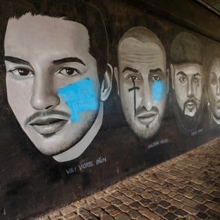 Das Gedenkbild für die Opfer des rassistischen Anschlags in Hanau unterhalb der Friedensbrücke in Frankfurt wurde beschmiert - auch mit volksverhetzenden Symbolen. Letztere wurden von der Polizei übersprüht.