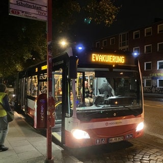 Ein Bus mit dem Schriftzug "Evakuierung" steht an einer Haltestelle. Auf dem Gelände einer Hamburger Grundschule ist ein Blindgänger aus dem Zweiten Weltkrieg gefunden worden. Die Bombe wurde kurz vor Mitternacht entschärft.