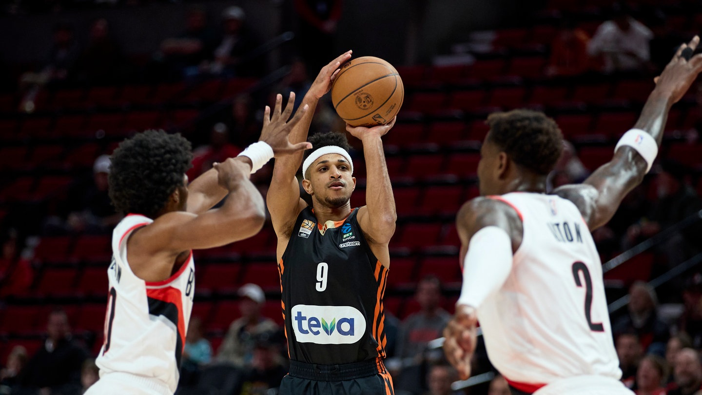 Ratiopharm Ulm Guard Alfonso Plummer (M) wirft zwischen Portland Trail Blazers Guard Scoot Henderson (l) und Center Deandre Ayton während der ersten Hälfte eines NBA-Testspiels.