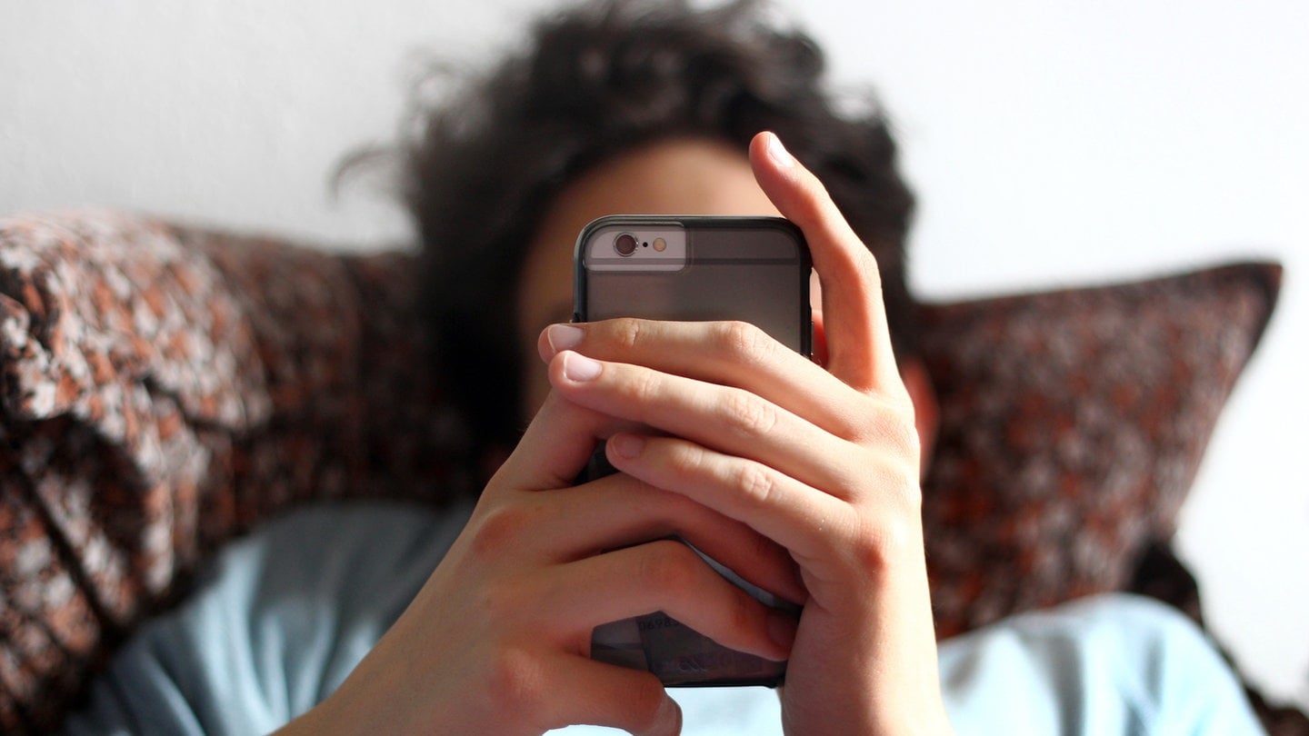 Ein Jugendlicher benutzt ein Smartphone. - Immer mehr Cybermobbing an Schulen: Diese schlimmen Folgen hat das!