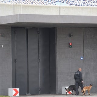 Justizangehöriger mit zwei Hunden vor der JVA Augsburg-Gablingen: Die Staatsanwaltschaft ermittelt wegen des Verdachts der Körperverletzung im Gefängnis.