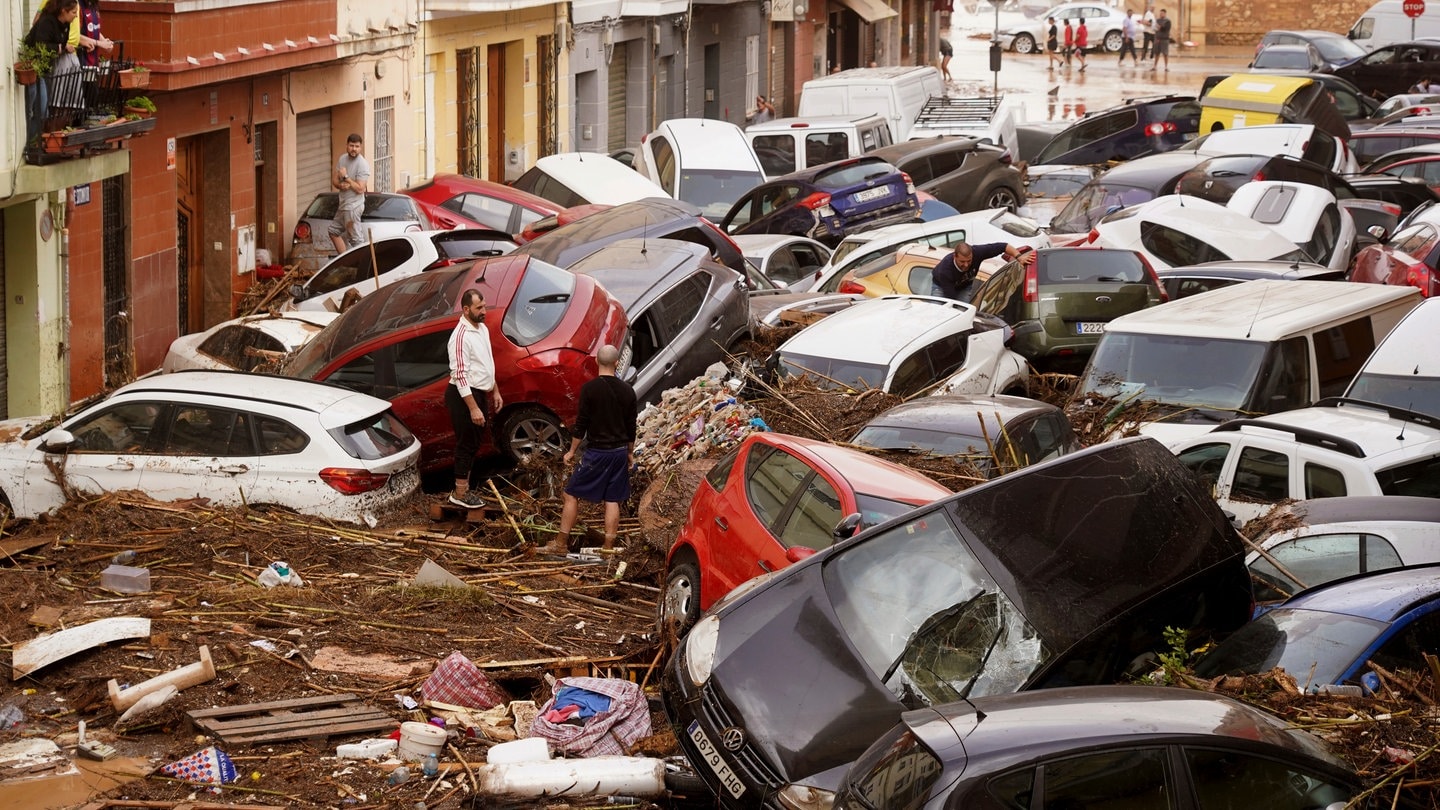 Nach Unwetter in Spanien: Anwohner betrachten durch die Wassermassen aufgestapelte Autos.