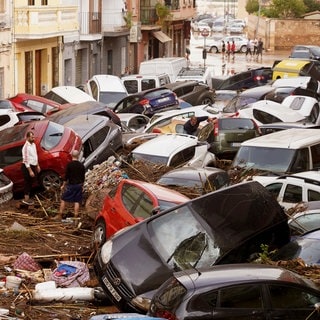 Nach Unwetter in Spanien: Anwohner betrachten durch die Wassermassen aufgestapelte Autos.