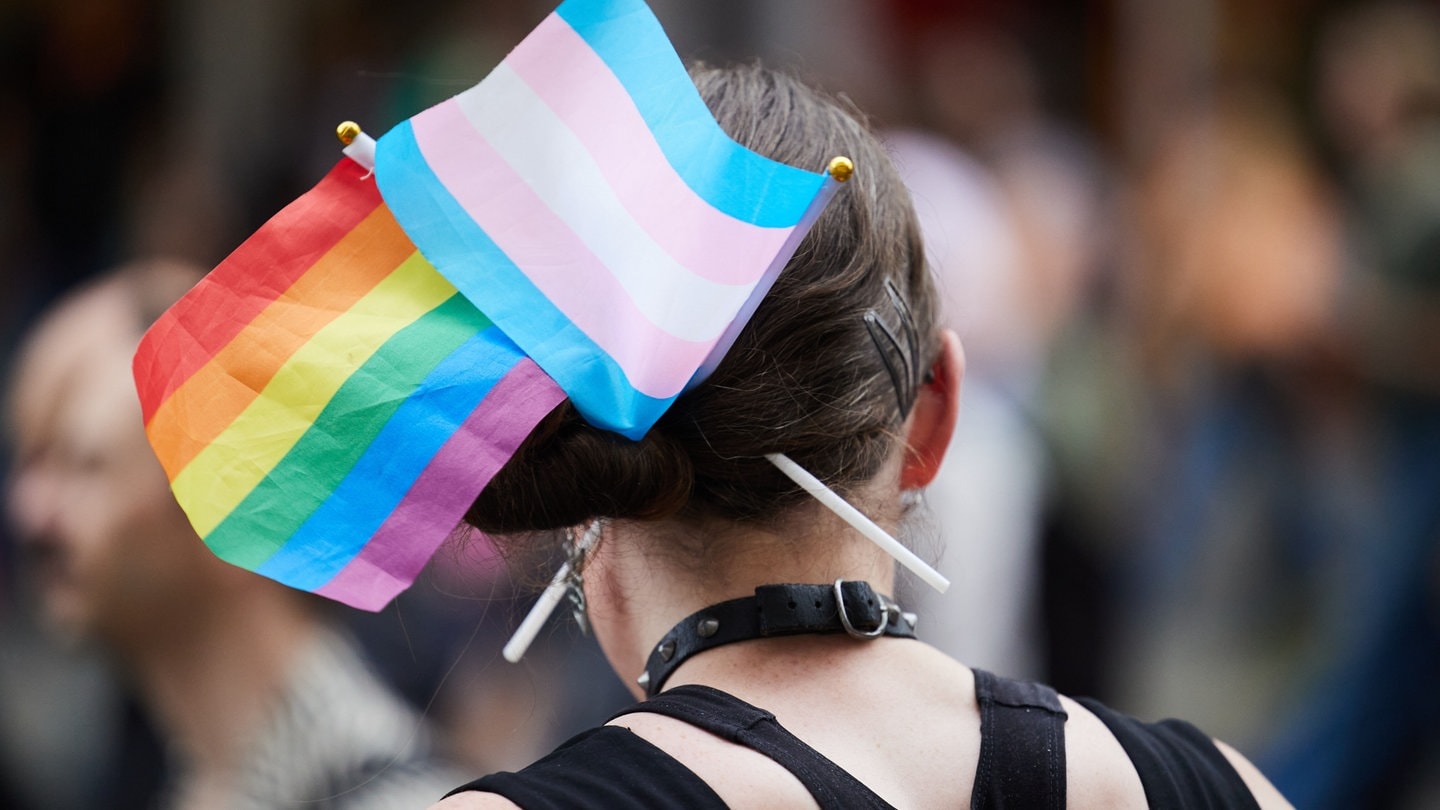 Frau mit Trans* und Queer-Flagge in den Haaren: Trans*Aktionswochen Rhein-Neckar starten