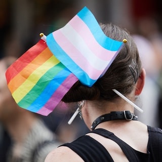 Frau mit Trans* und Queer-Flagge in den Haaren: Trans*Aktionswochen Rhein-Neckar starten