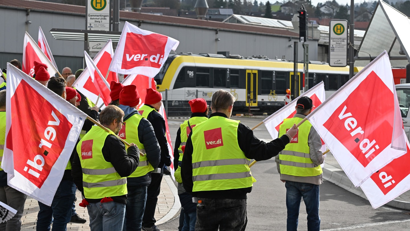 Mitarbeiter der Südwestdeutschen Landesverkehrs GmbH (SWEG) stehen bei einer Kundgebung im Rahmen eines Warnstreiks auf vor dem Bahnhof in Gammertingen.