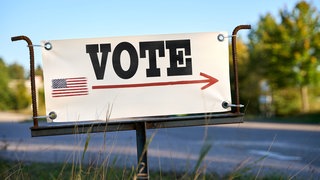 Wegweiser mit der USA Flagge und der Aufschrift: "Vote!": Kurz vor der US-Wahl haben konservative Aktivisten in Pennsylvania Tausende Beschwerden gegen Briefwähler eingereicht.