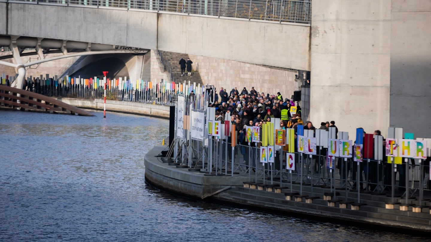 Eine Plakat-Aktion zum Erinnern an den Mauerfall: Die Plakate zeichnen zum 35. Jahrestag entlang der Spree den Weg der Berliner Mauer nach.