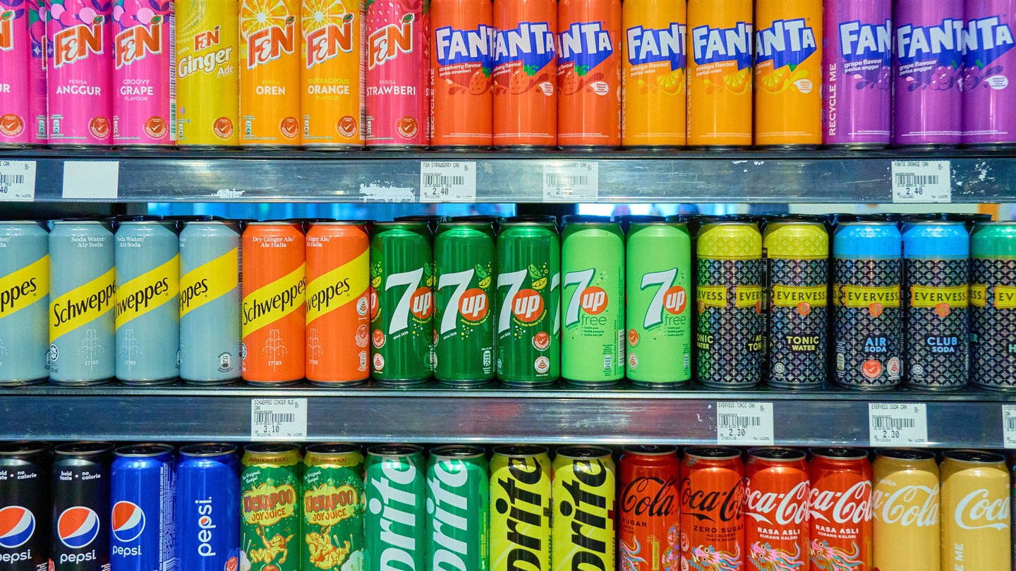 Getränkedosen in einem Supermarkt Kühlregal von Coca Cola, Sprite, Pepsi, Schweppes und Fanta