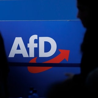 Delegierte gehen vor dem Parteilogo bei dem AfD-Bundesparteitag - Der Verfassungsschutz in Baden-Württemberg darf den Landesverband der AfD