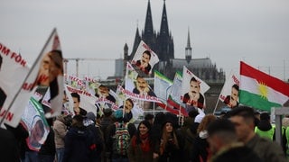 Teilnehmer der Kundgebung des kurdischen Dachverbands Kon-Med halten Fahnen hoch. Die Kundgebung steht unter dem Motto «Freiheit für Öcalan».