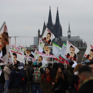 Teilnehmer der Kundgebung des kurdischen Dachverbands Kon-Med halten Fahnen hoch. Die Kundgebung steht unter dem Motto «Freiheit für Öcalan».