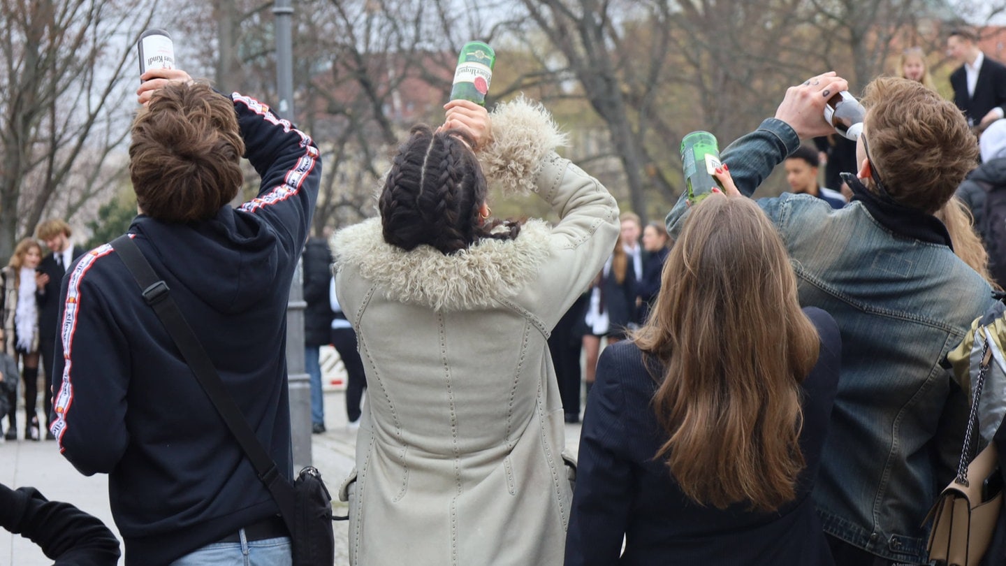 Vier junge Menschen trinken Alkohol.