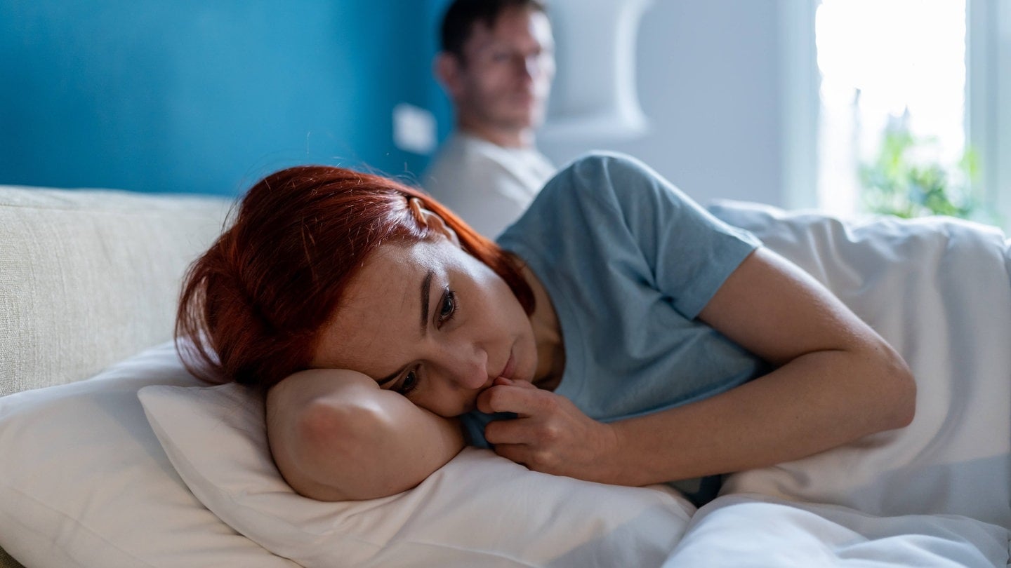 Symbolbild häusliche Gewalt. Frau und Mann im Schlafzimmer.