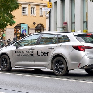 Uber-Fahrer mit Uberschrift auf Auto