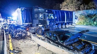 Ein Lastwagen steht auf der Autobahn 1 bei Hagen an der Unfallstelle neben beschädigten Autos. Nach einer Chaosfahrt über mehrere Autobahnen hat die Polizei in Nordrhein-Westfalen einen auffälligen Lkw-Fahrer aus dem Verkehr gezogen. Es habe mehrere Unfälle und Sachschäden gegeben, wie die Polizei mitteilte.