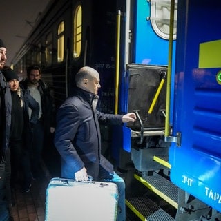 Bundeskanzler Olaf Scholz steigt in Begleitung von Sicherheitskräften auf dem Bahnhof der polnischen Grenzstadt Przemysl in den Sonderzug für die Fahrt in die ukrainische Hauptstadt Kyjiw.