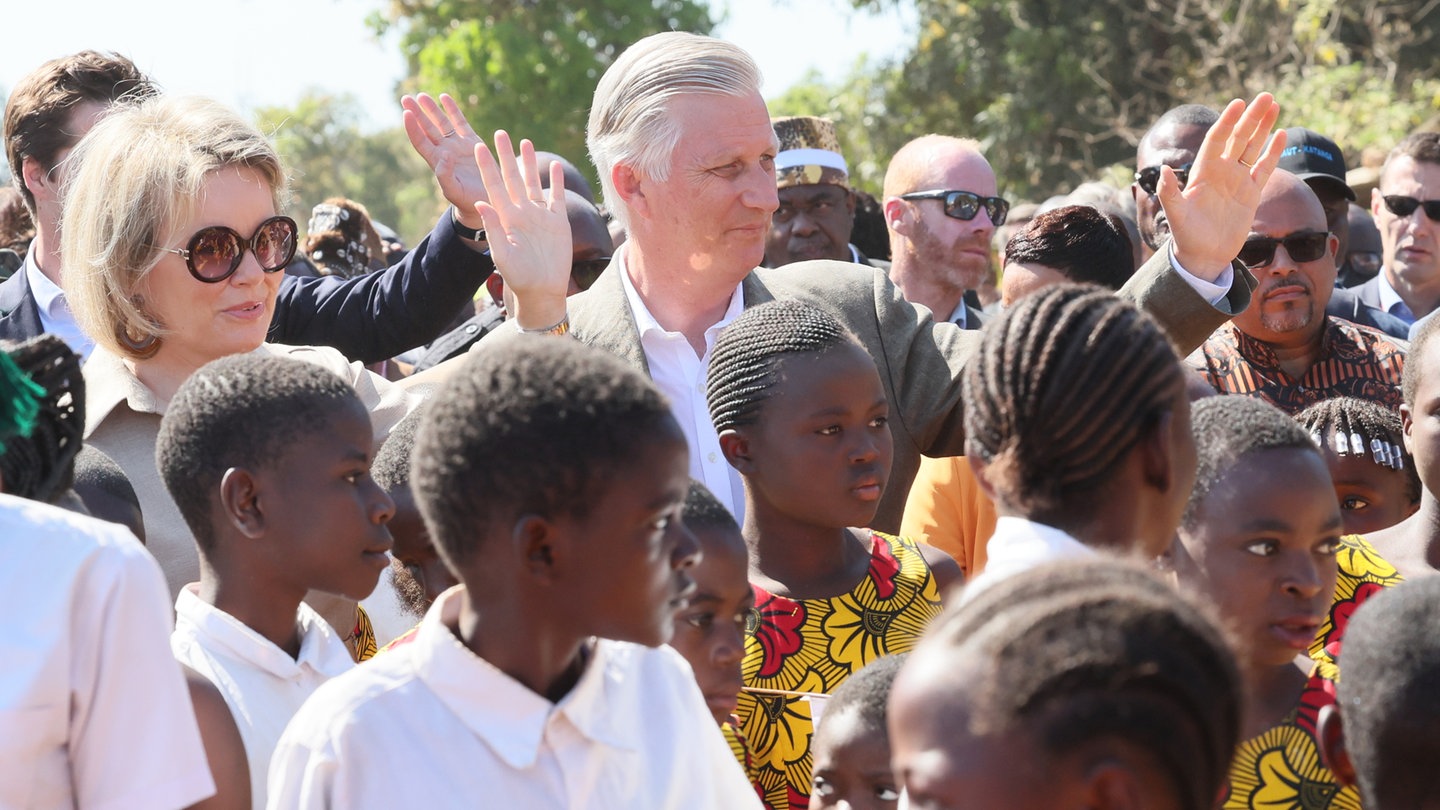 König Philippe und Königin Mathilde von Belgien grüßen Einheimische im Kongo. Ein Gericht hat Belgien jetzt Verbrechen gegen die Menschlichkeit vorgeworfen. Es geht um die belgische Kolonialzeit im Kongo.