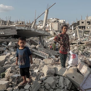 Zwei Kinder stehen auf den Trümmern von zerstörten Gebäuden im südlichen Gazastreifen.