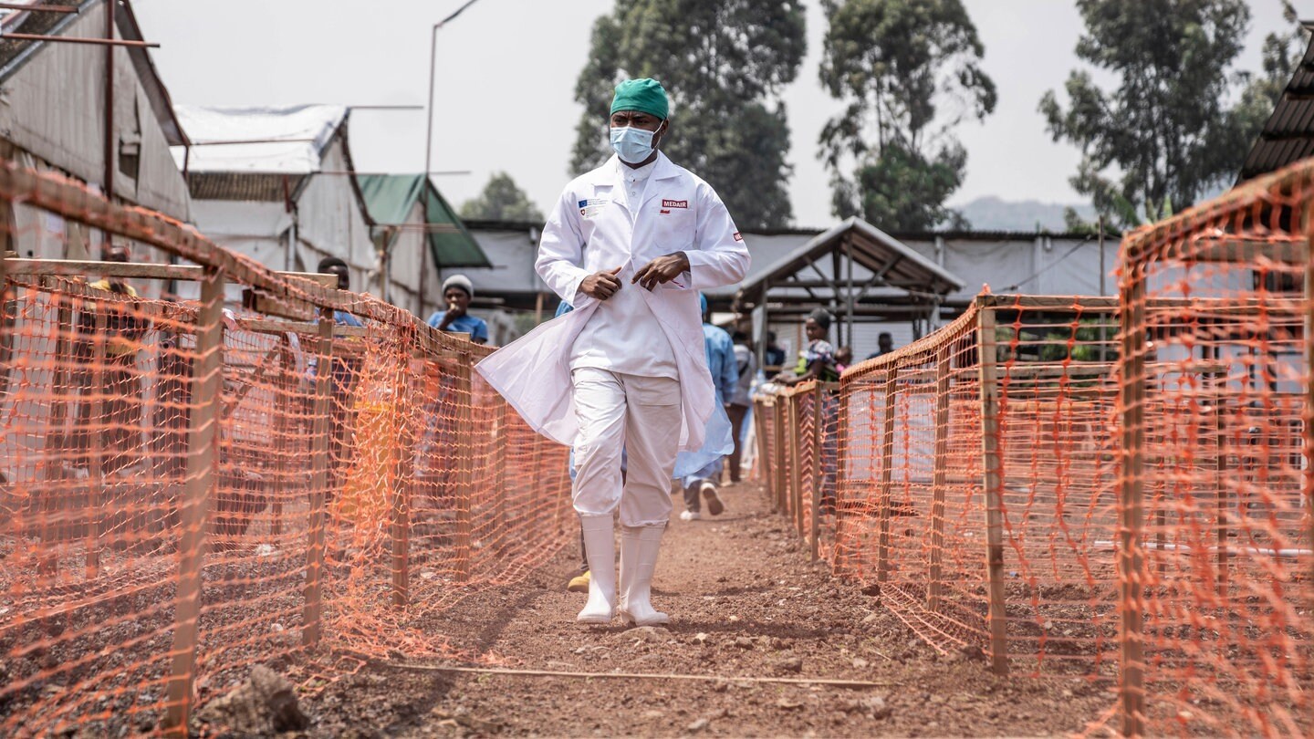 Ein Gesundheitsarbeiter geht an einem Mpox-Behandlungszentrum in der Demokratischen Republik Kongo vorbei. Zusätzlich mit dem andauernden Ausbruch gibt nun eine neue Krankheit Rätsel auf.