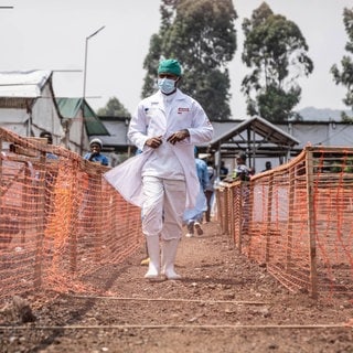 Ein Gesundheitsarbeiter geht an einem Mpox-Behandlungszentrum in der Demokratischen Republik Kongo vorbei. Zusätzlich mit dem andauernden Ausbruch gibt nun eine neue Krankheit Rätsel auf. 