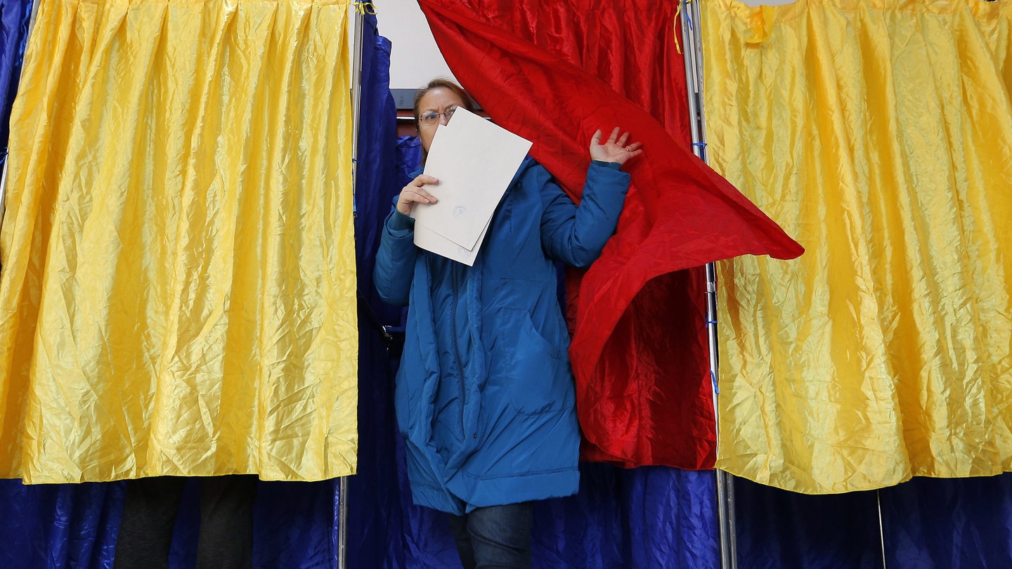 Eine Frau in Rumänien kommt aus der Wahlkabine. Die erste Runde der Präsidentschaftswahl wurde für ungültig erklärt und muss wiederholt werden.