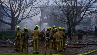 Feuerwehrleute arbeiten nach einer Explosion in einem Wohnblock.