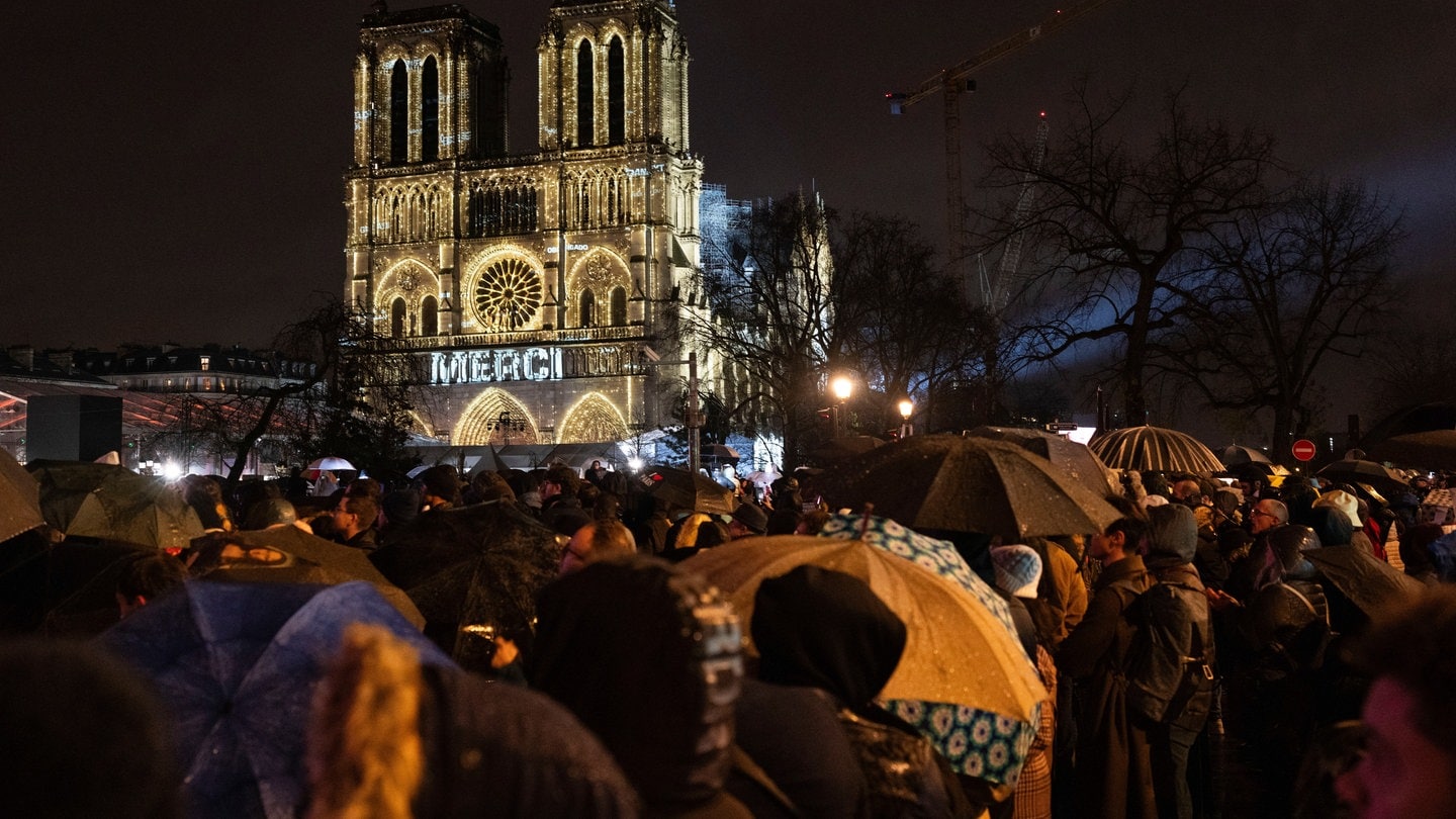 Zuschauer versammeln sich vor der Kathedrale Notre-Dame in Paris.