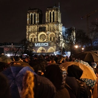 Zuschauer versammeln sich vor der Kathedrale Notre-Dame in Paris.