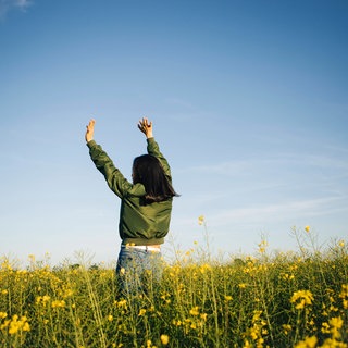 Symbolfoto: Junge Frau in Feld mit Blumen