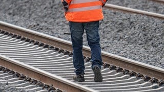 Ein Arbeiter geht auf der Riedbahnbaustelle am Bahnhof Gernsheim auf den Gleisen. (Archivbild)