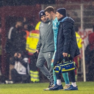 1. FC Union Berlin - VfL Bochum, 14. Spieltag, An der Alten Försterei. Torwart Patrick Drewes vom VfL Bochum wird vom Platz geführt, nachdem er von einem Feuerzeug am Kopf getroffen wurde.