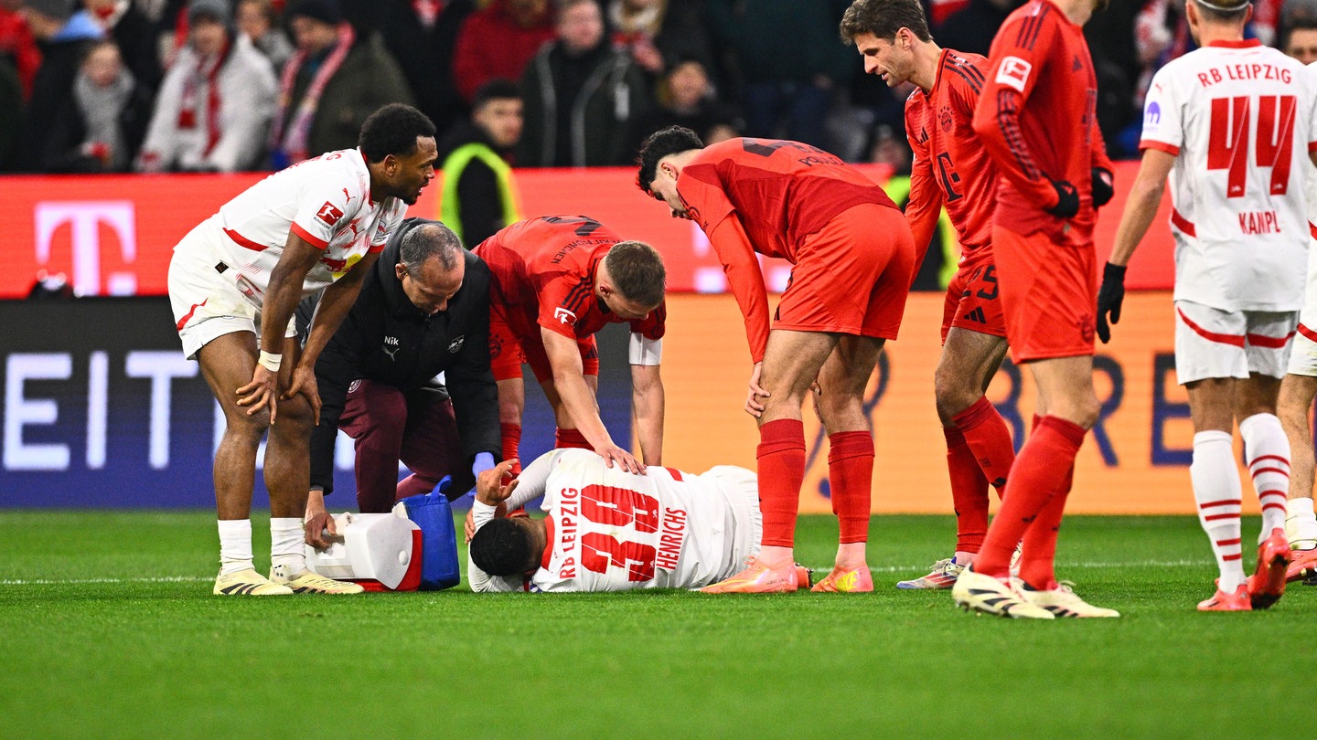 Bundesliga, Bayern München - RB Leipzig. Leipzigs Benjamin Henrichs liegt verletzt auf dem Rasen.