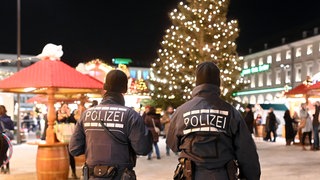 Polizisten gehen über den Weihnachtsmarkt. Nach dem mutmaßlichen Anschlag auf Weihnachtsmarkt in Magdeburg ist in Baden-Württemberg mehr Polizei unterwegs.