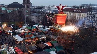 Der Hochseilartist Falko Traber steht am 05.12.2017 über dem Weihnachtsmarkt von Karlsruhe (Baden-Württemberg) als Weihnachtsmann verkleidet in einem Schlitten. Auf einem Seil und von einem Motor angetrieben fährt der von Rentiermodellen gezogene Schlitten mit dem fliegenden Weihnachtsmann derzeit zwei Mal am Abend über den Weihnachtsmarkt