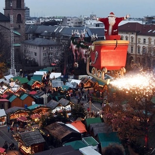 Der Hochseilartist Falko Traber steht am 05.12.2017 über dem Weihnachtsmarkt von Karlsruhe (Baden-Württemberg) als Weihnachtsmann verkleidet in einem Schlitten. Auf einem Seil und von einem Motor angetrieben fährt der von Rentiermodellen gezogene Schlitten mit dem fliegenden Weihnachtsmann derzeit zwei Mal am Abend über den Weihnachtsmarkt