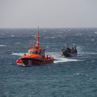 Eines von zwei Booten kommt im Hafen von La Restinga an. Auf dem ersten Boot, das auf der Insel ankam, befanden sich über 100 Menschen, darunter mehrere Frauen. Nach der Ausschiffung wurden mehrere dieser Personen wegen körperlicher Beschwerden ins Krankenhaus gebracht. Das zweite Boot erreichte den Hafen eine Stunde später.