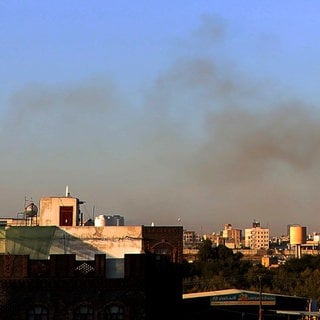 Nach einem Luftangriff steigt Rauch aus der Umgebung des internationalen Flughafens auf, gesehen von Sanaa, Jemen. Das israelische Militär gab an, die von den Huthis genutzte Infrastruktur des internationalen Flughafens von Sanaa sowie Häfen in Hodeida, Al-Salif und Ras Qantib sowie Kraftwerke ins Visier genommen zu haben. Bei dem israelischen Angriff auf den Flughafen in Sanaa ist auch ein Team der Weltgesundheitsorganisation um WHO-Chef Tedros Adhanom Ghebreyesus unter Feuer geraten.