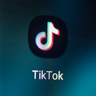 Auf dem Bildschirm eines Smartphones sieht man das Logo der App TikTok.