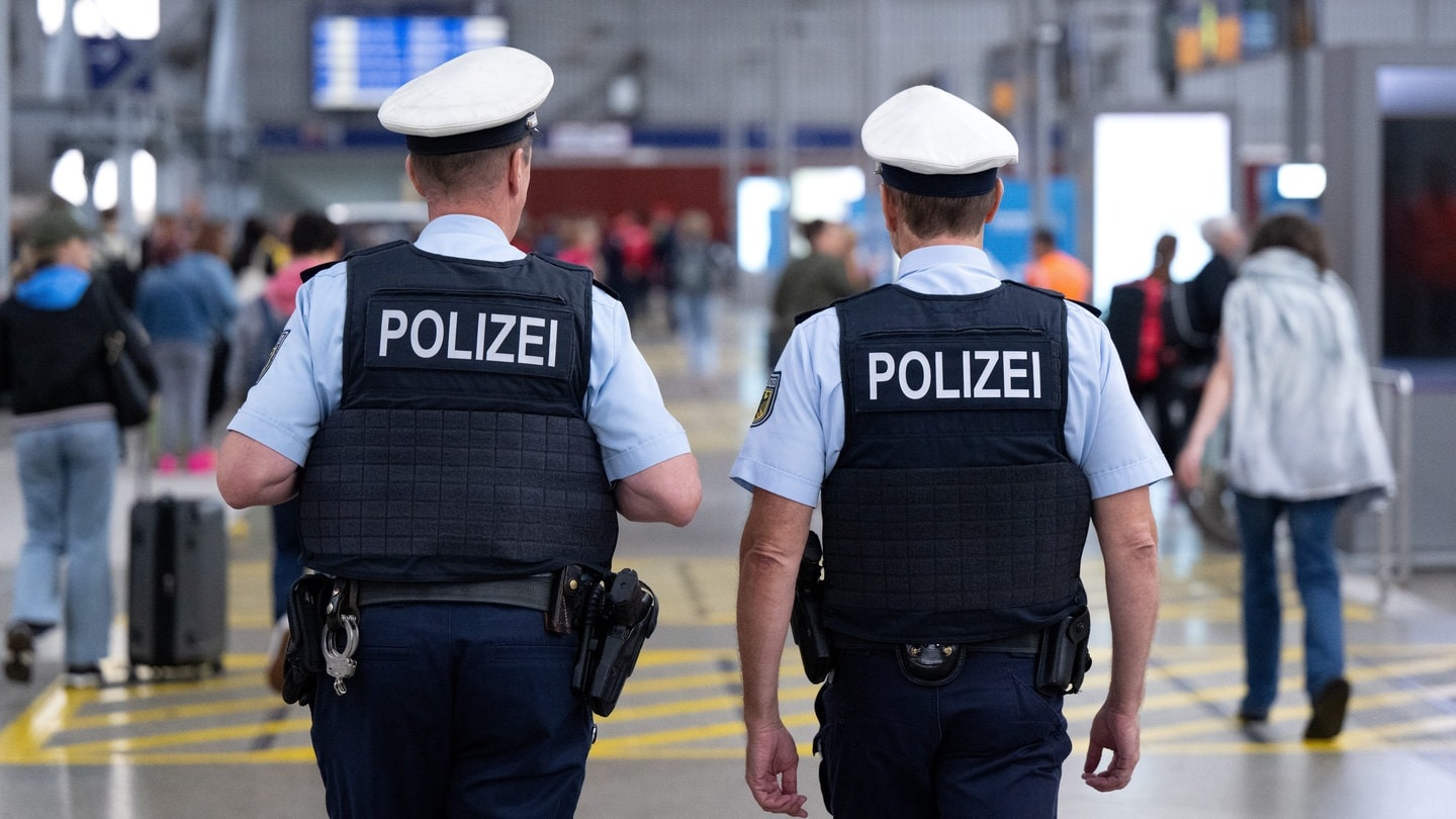 Bundespolizisten gehen durch einen Hauptbahnhof