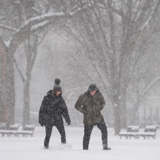 Wintersturm in den USA: Menschen gehen während eines Schneesturms in Washington spazieren.