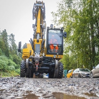 Symbolbild: Ein gelber Bagger fährt auf der Straße