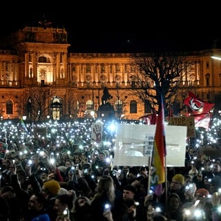 Demonstranten halten ihre Smartphones hoch während eines Protests gegen die Bildung einer österreichischen Rechts-Regierung unter Führung der FPÖ.