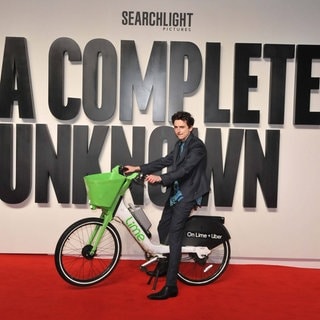 Timothée Chalamet bei der britischen Filmpremiere von "A Complete Unknown" mit einem Lime-Leihfahrrad auf dem roten Teppich.