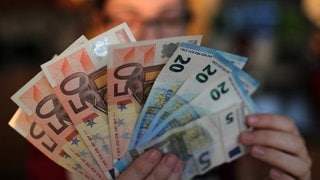 Eune Jugendliche hält Euro-Scheine in der Hand. Laut einer neuen Studie kannst du durch einen Jobwechsel mehr Geld verdienen und zufriedener sein.