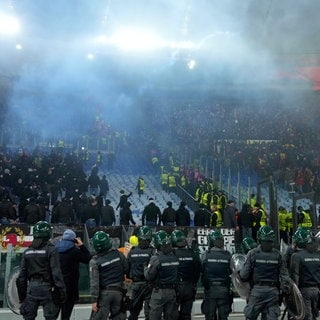 Fußball: Europa League, AS Rom - Eintracht Frankfurt, Vorrunde, 8. Spieltag, Stadio Olimpico, Polizisten stehen vor den Zuschauerrängen während Sicherheitskräfte versuchen die Fangruppen voneinander zu trennen.